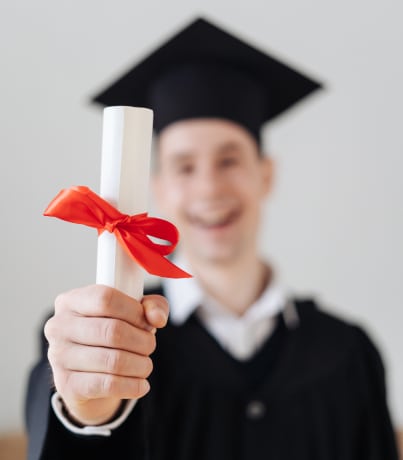 A man wearing toga holding a rolled certificate.